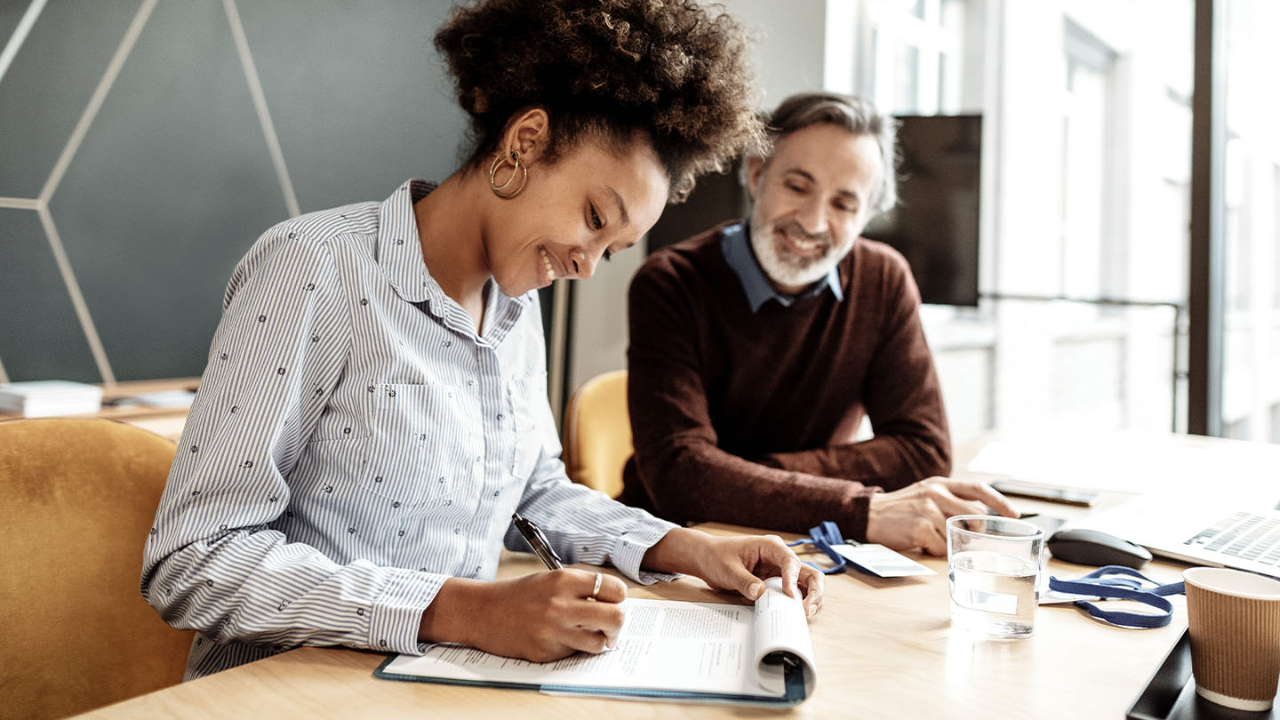 Two individuals at a table with papers